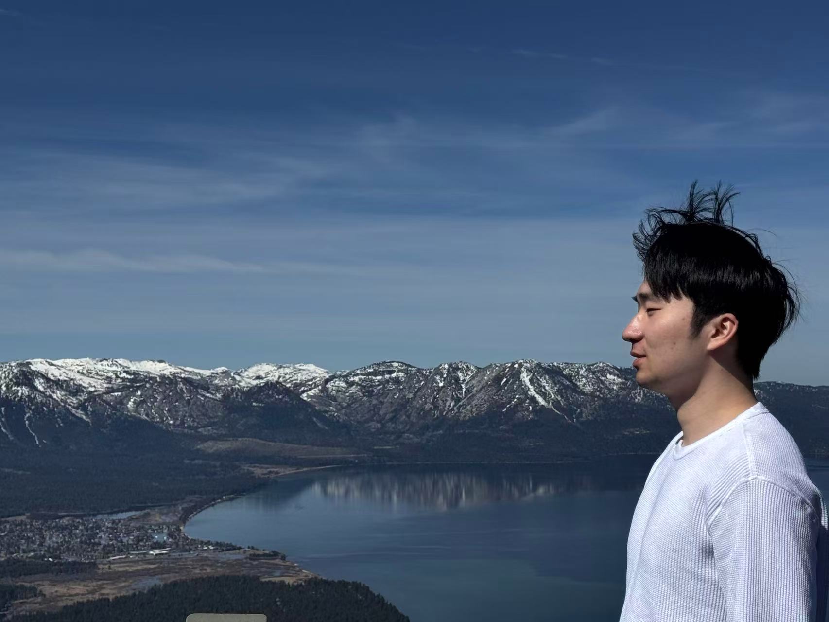 Ziang Tan outdoors above a mountain lake.