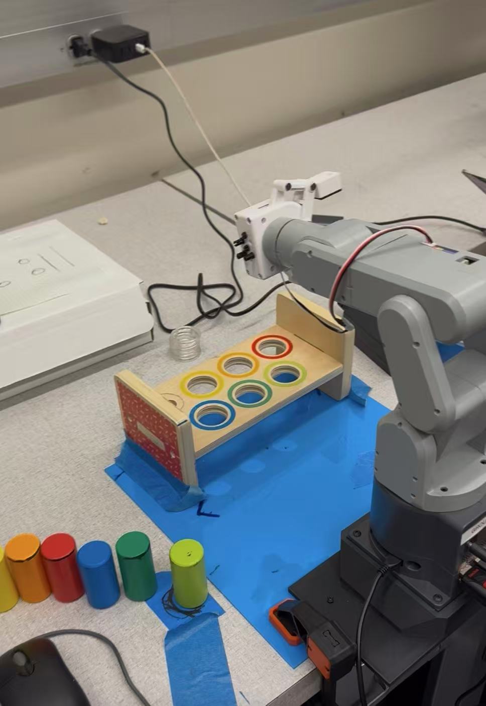 Robotic arm sorting colored objects on a tabletop.